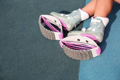 Woman with kangoo jumping boots on color textured background, closeup. Space for text