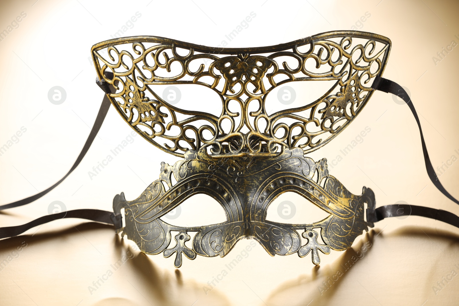 Photo of Elegant face masks on beige background. Theatrical performance