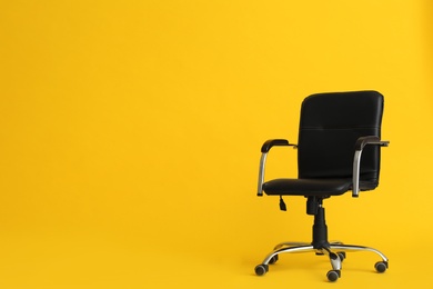 Modern office chair on yellow background. Space for text