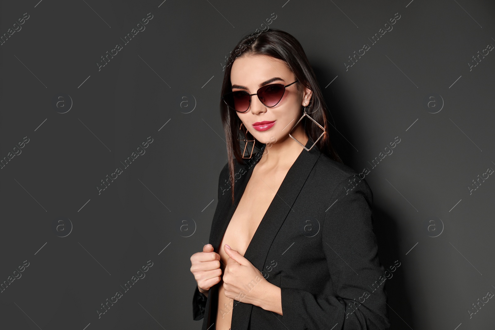 Photo of Beautiful woman wearing jacket and sunglasses on black background