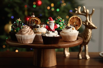 Many different Christmas cupcakes on wooden table indoors