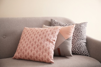 Photo of Different soft pillows on sofa in room