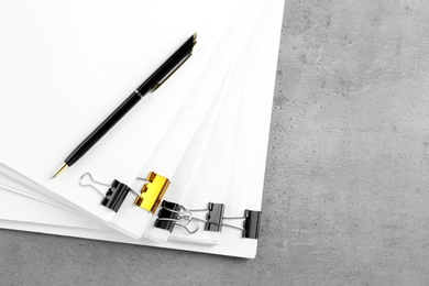 Photo of Stack of documents with binder clips on light table, top view