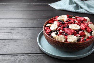 Bowl of different freeze dried fruits on wooden table. Space for text