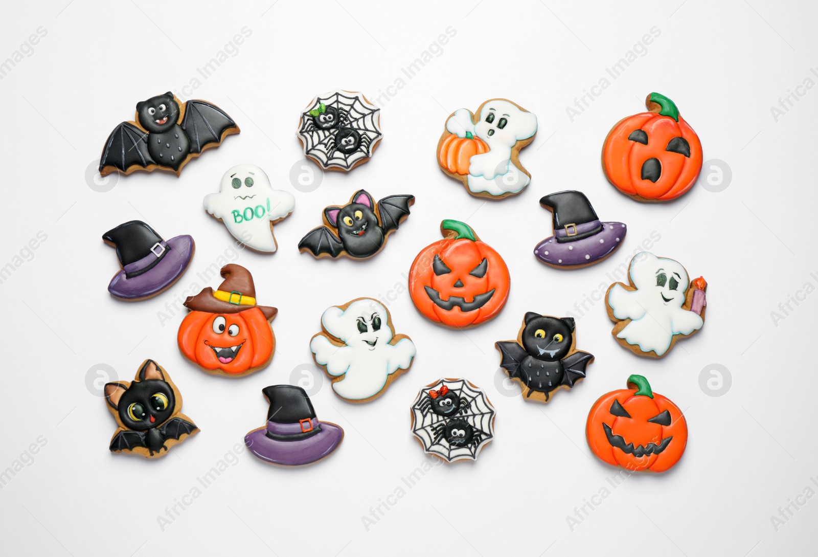 Photo of Tasty Halloween cookies on white table, flat lay
