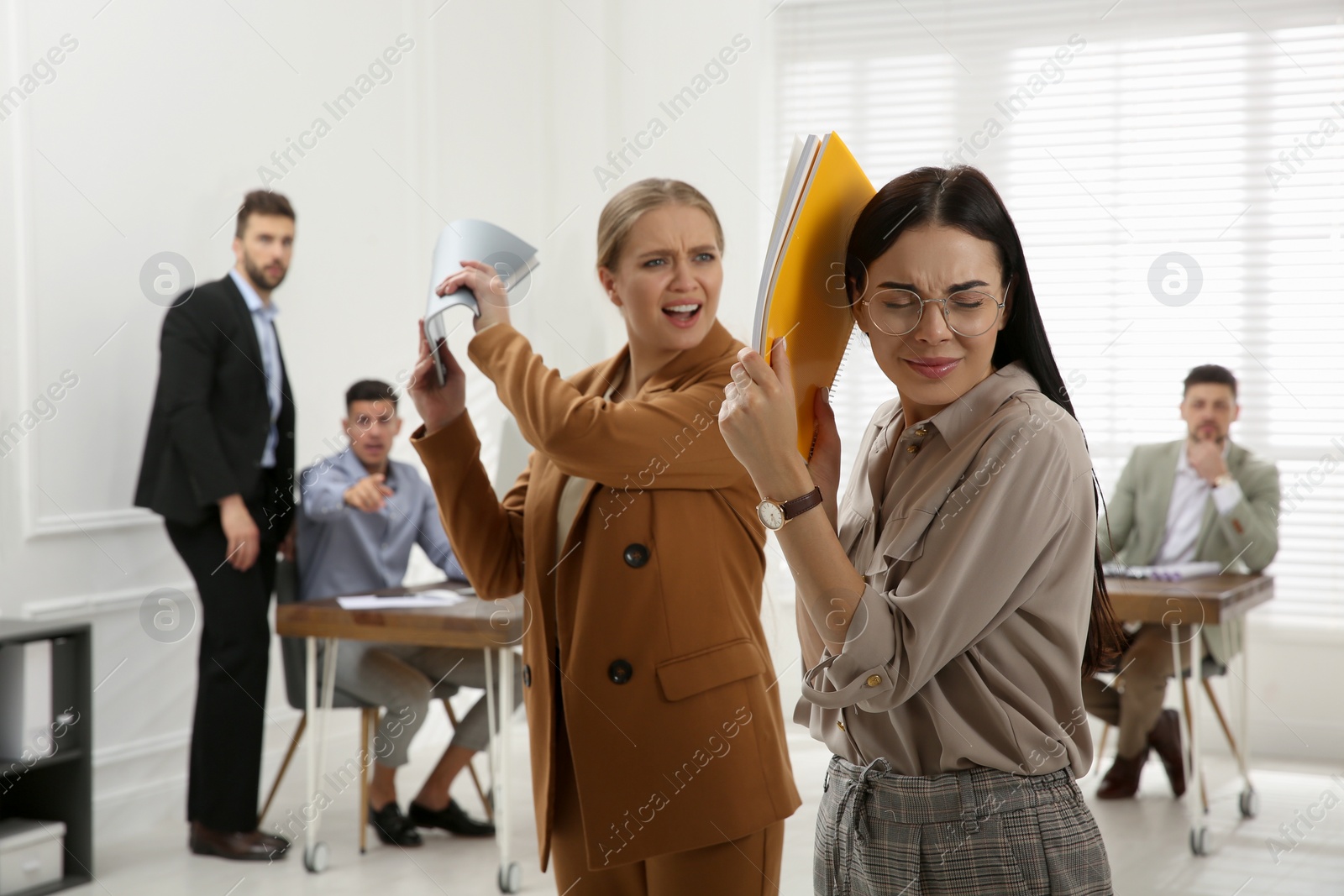 Photo of Emotional colleagues fighting in office. Workplace conflict