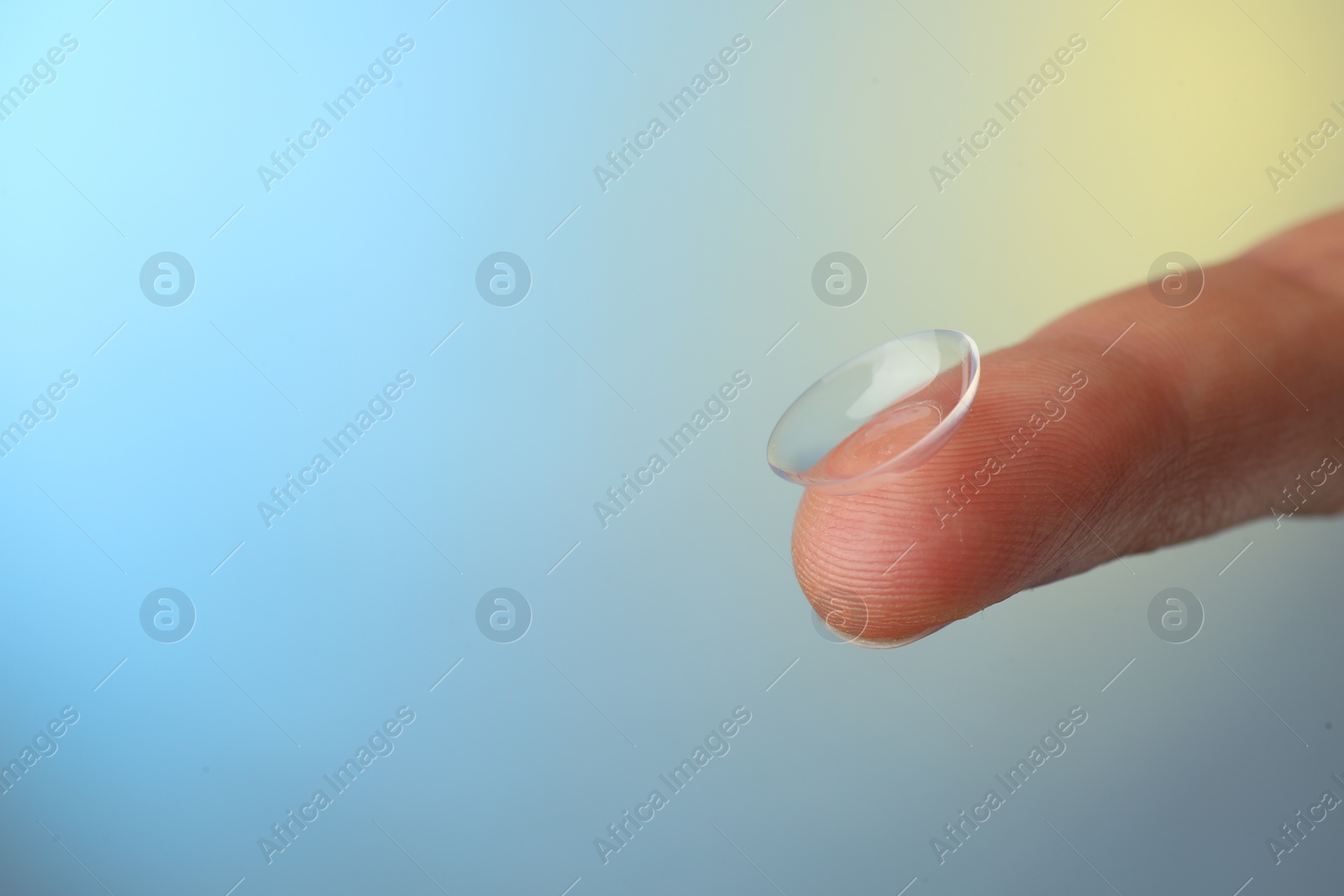 Photo of Woman holding contact lens on color background, closeup. Space for text