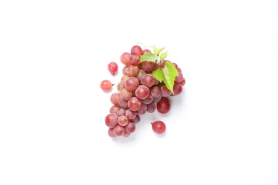 Bunch of ripe red grapes with green leaves on white background, top view