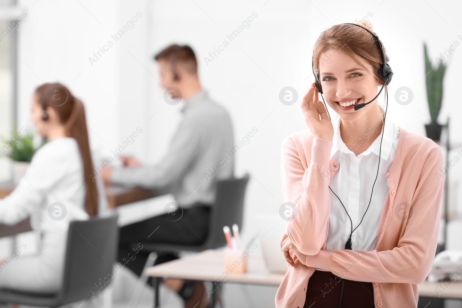 Photo of Young female receptionist with headset in office