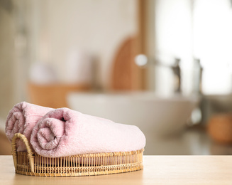 Image of Fresh towels on wooden table in bathroom. Space for text