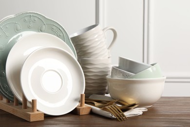 Beautiful ceramic dishware, cups and cutlery on wooden table