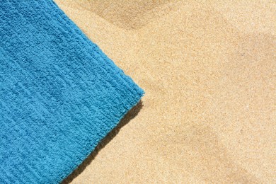 Photo of Soft blue beach towel on sand, top view. Space for text