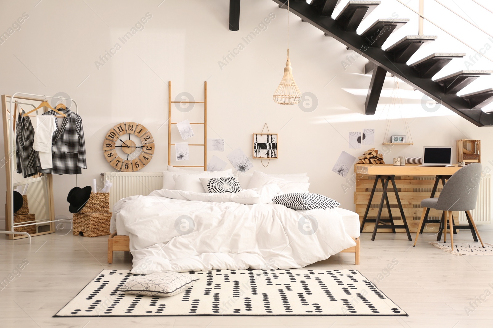 Photo of Elegant interior of bedroom with workplace under stairs