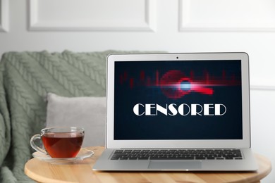 Image of Laptop with censorship sign on wooden table indoors