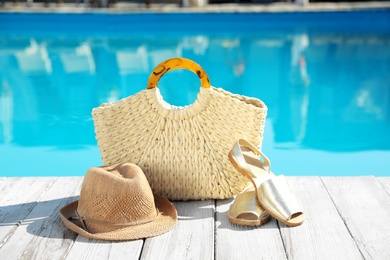 Beach accessories on wooden deck near outdoor swimming pool