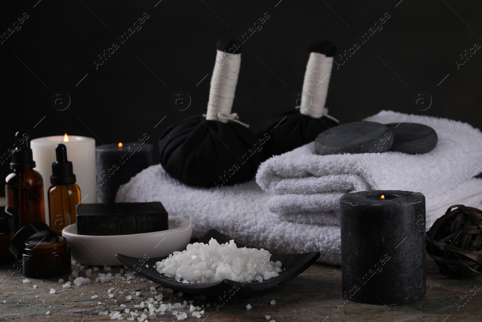 Photo of Composition with different spa products and burning candles on grey textured table