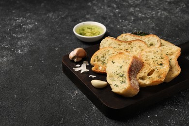 Photo of Tasty baguette with garlic and dill served on grey textured table, space for text