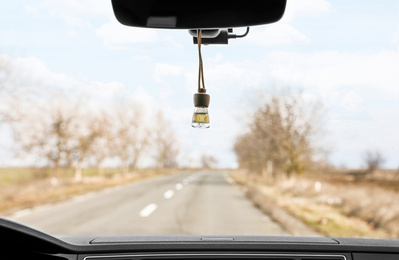 Photo of Air freshener hanging on rear view mirror in car