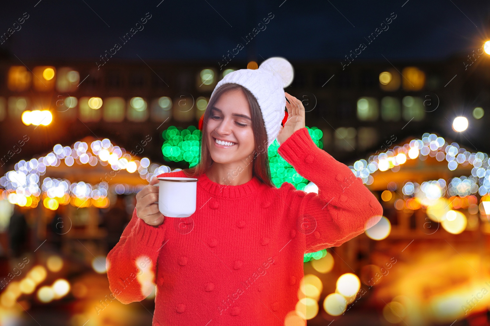 Image of Happy beautiful woman with mug of mulled wine at Christmas fair