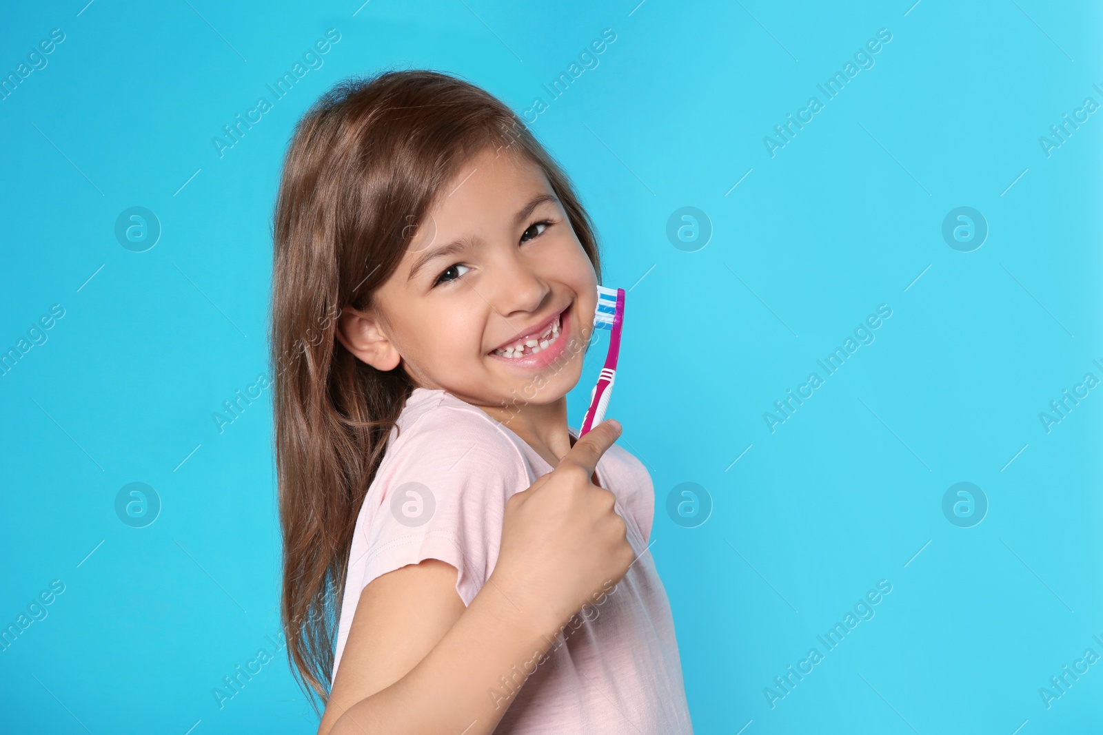 Photo of Portrait of little girl with toothbrush on color background. Space for text