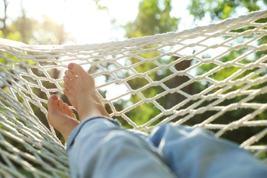 Photo of Young woman resting in comfortable hammock at green garden, closeup