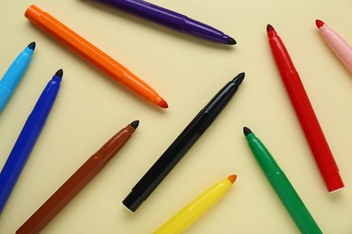 Photo of Many different colorful markers on beige background, flat lay