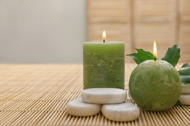Composition with spa stones and candles on bamboo mat. Space for text