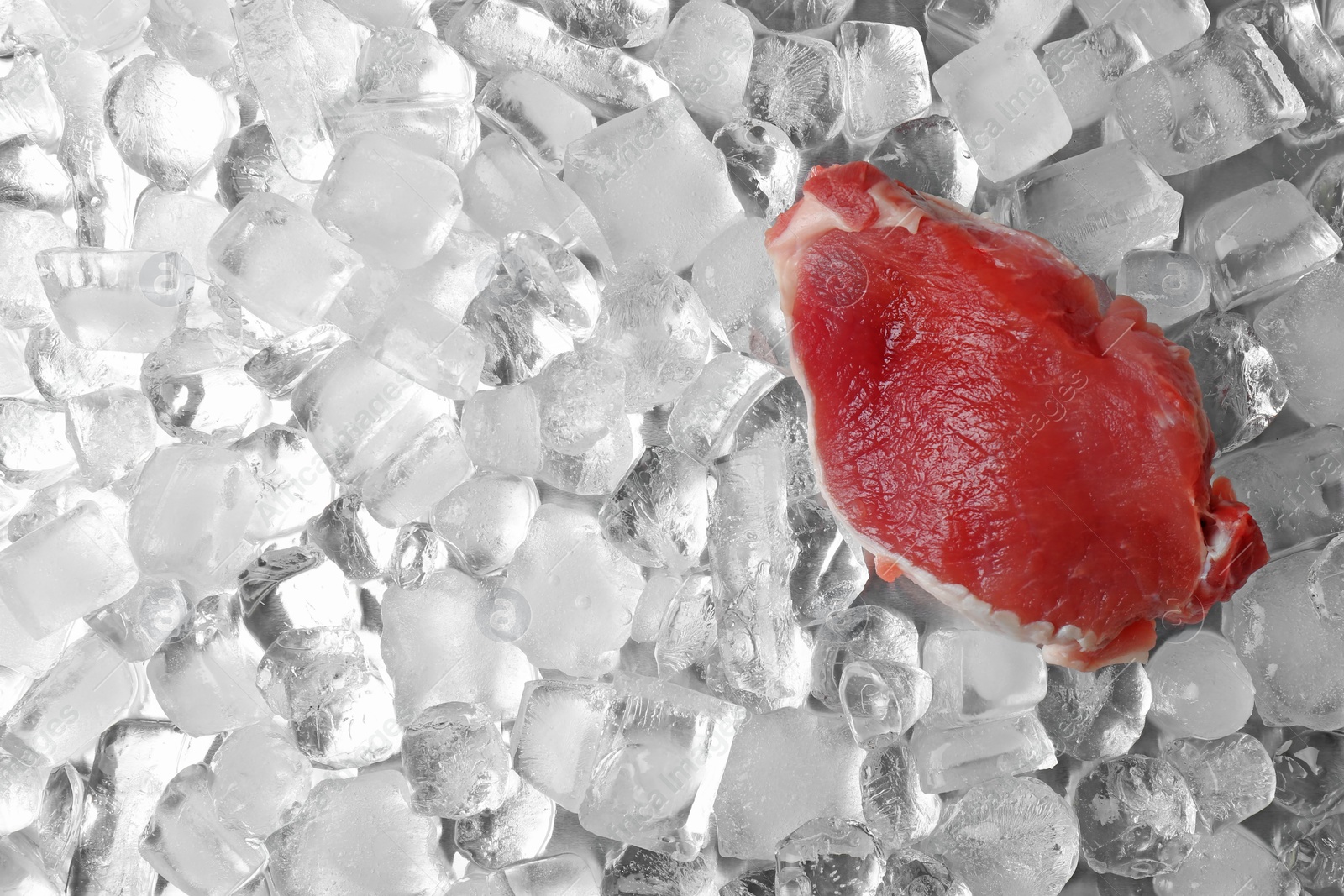 Photo of Fresh raw meat on ice cubes, top view