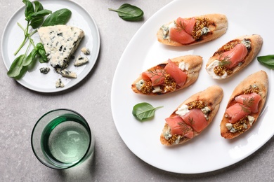 Flat lay composition with tasty bruschettas on grey table