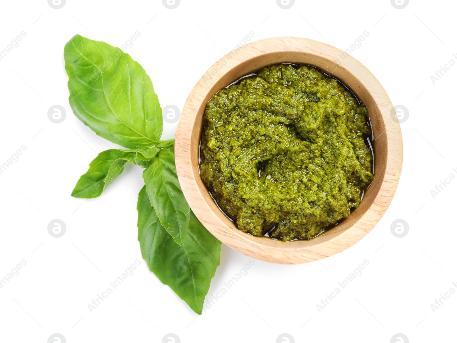 Photo of Fresh tasty pesto sauce and basil isolated on white, top view