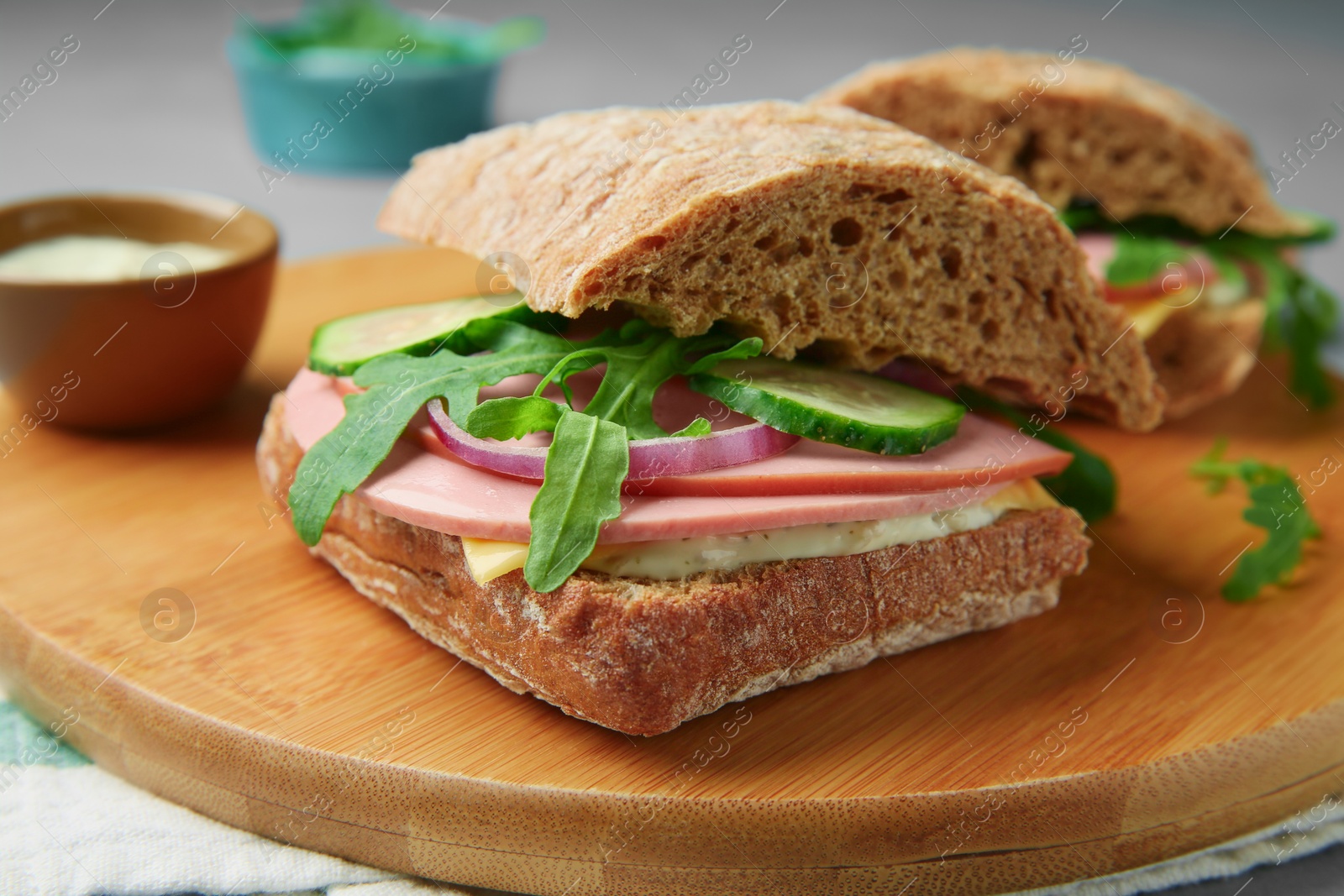 Photo of Tasty sandwiches with boiled sausage, cucumber and arugula on table, closeup