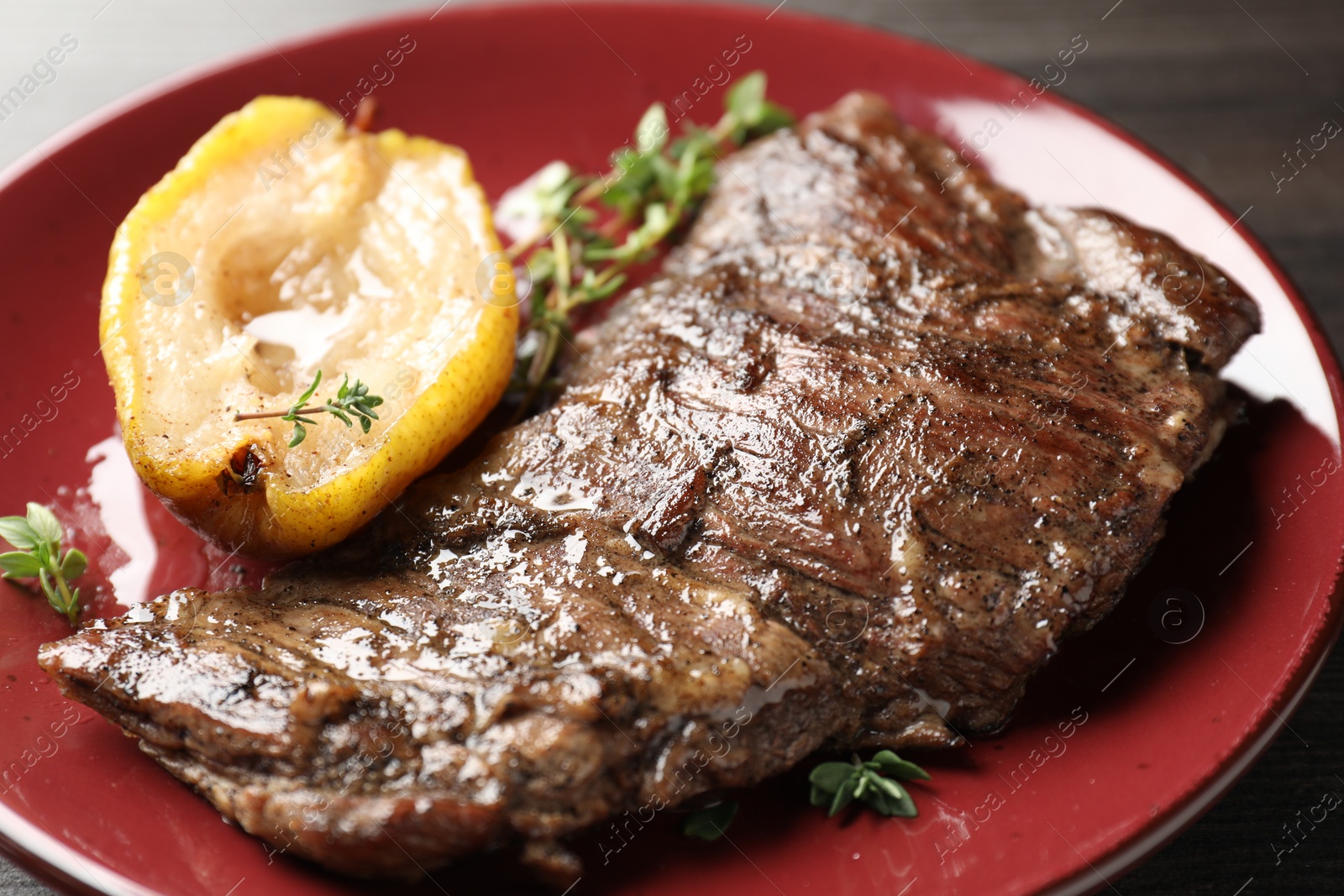 Photo of Delicious roasted beef meat, caramelized pear and thyme on table, closeup