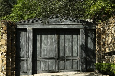 Photo of Beautiful vintage black wooden gates and stone fence outdoors