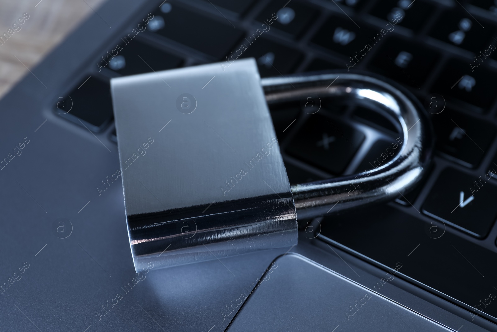 Photo of Cyber security. Laptop with padlock on table, closeup