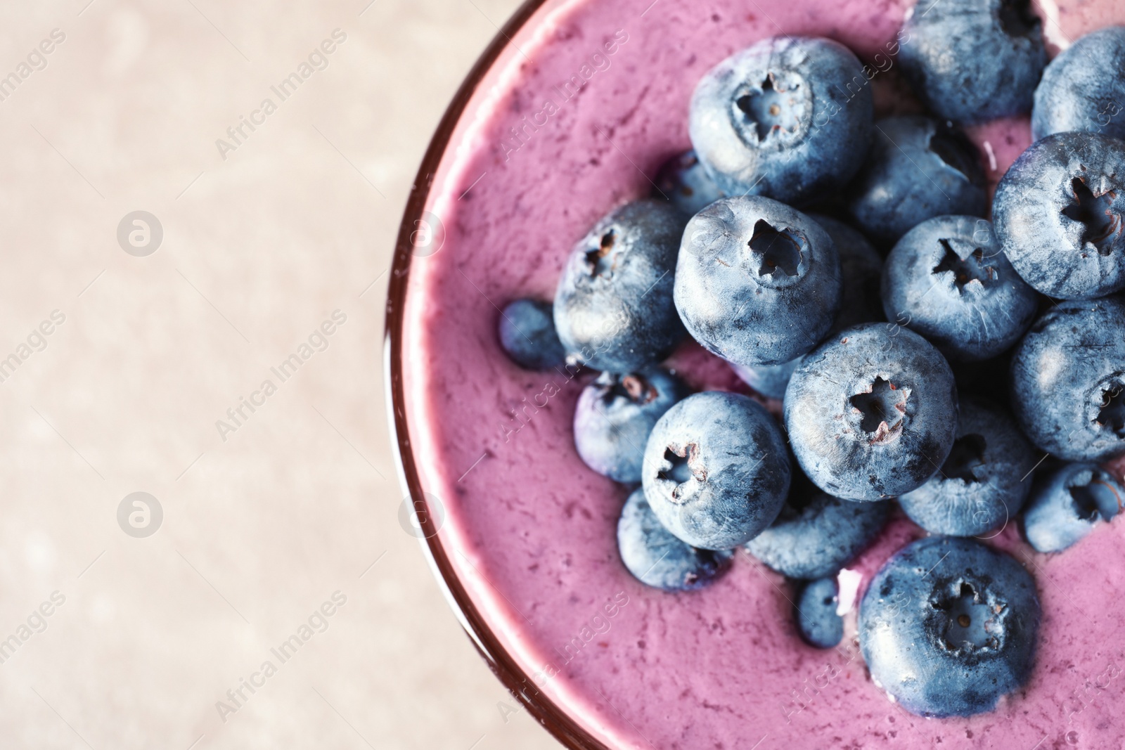 Photo of Glass with blueberry smoothie on grey background, top view