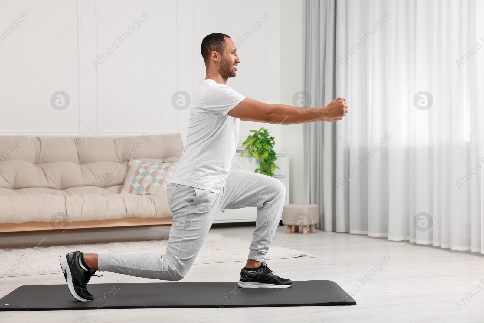 Photo of Man doing morning exercise on fitness mat at home