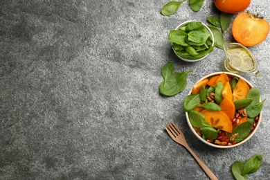 Delicious persimmon salad served on grey table, flat lay. Space for text