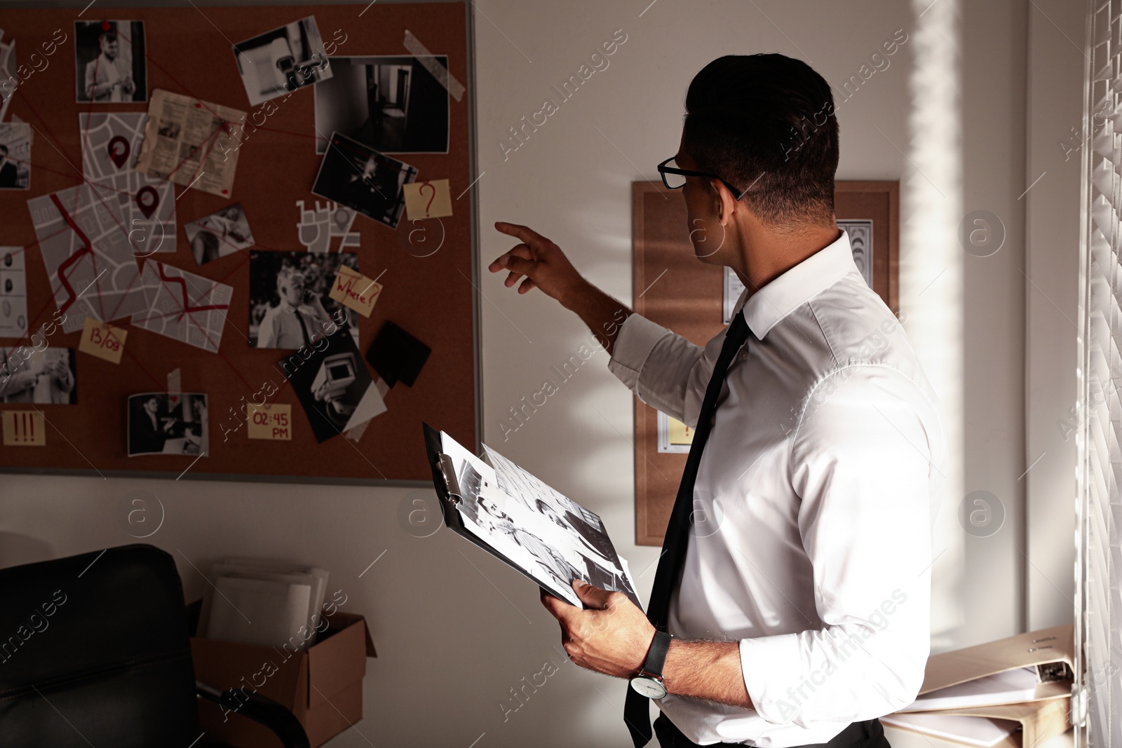 Photo of Detective with clipboard working in his office