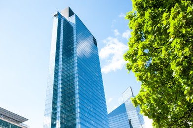 Photo of Stylish buildings with many windows under cloudy sky, low angle view