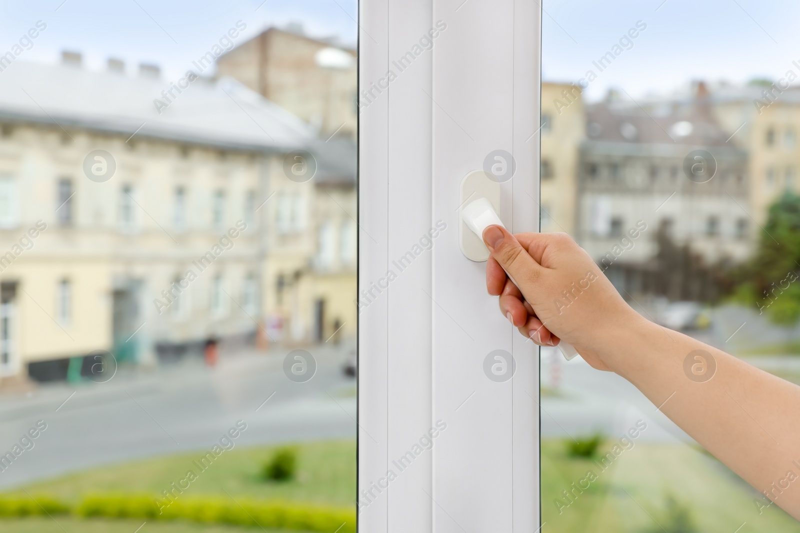 Photo of Woman opening white plastic window at home, closeup