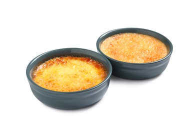Photo of Delicious creme brulee in ceramic ramekins on white background