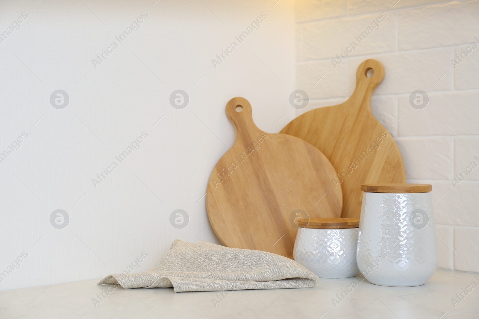 Photo of Wooden boards, napkin and kitchen items on countertop indoors