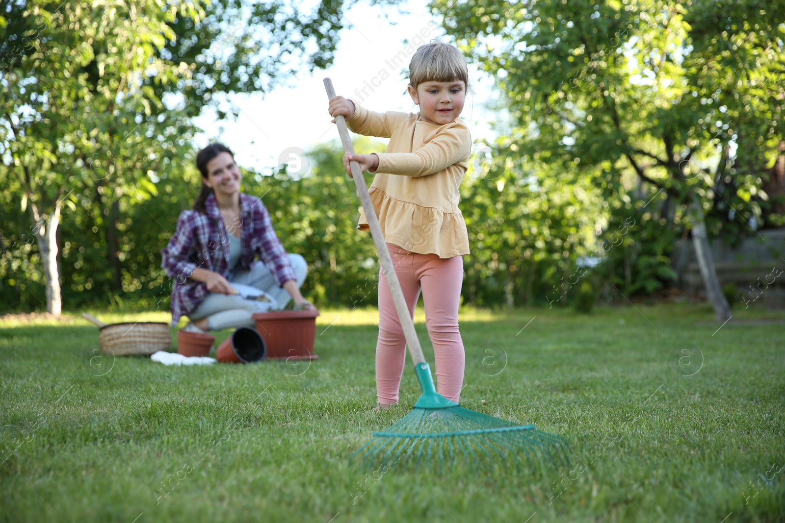 Photo of Mother and her daughter working together in garden