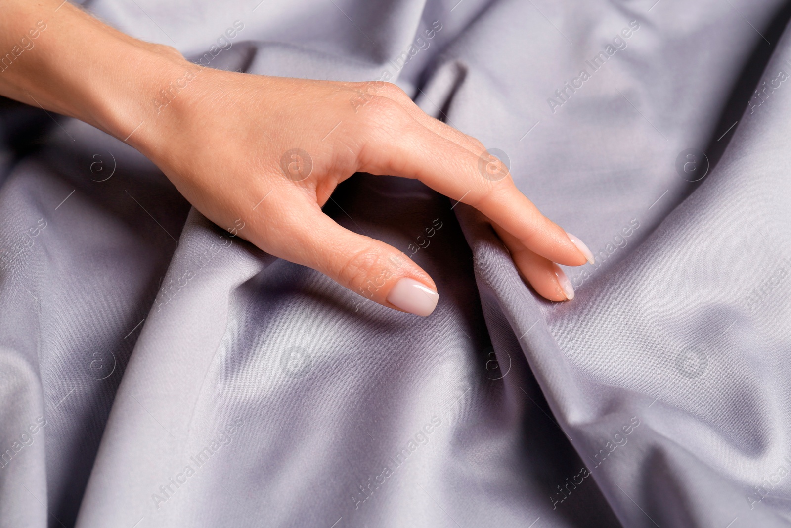 Photo of Woman touching soft silver fabric, closeup view