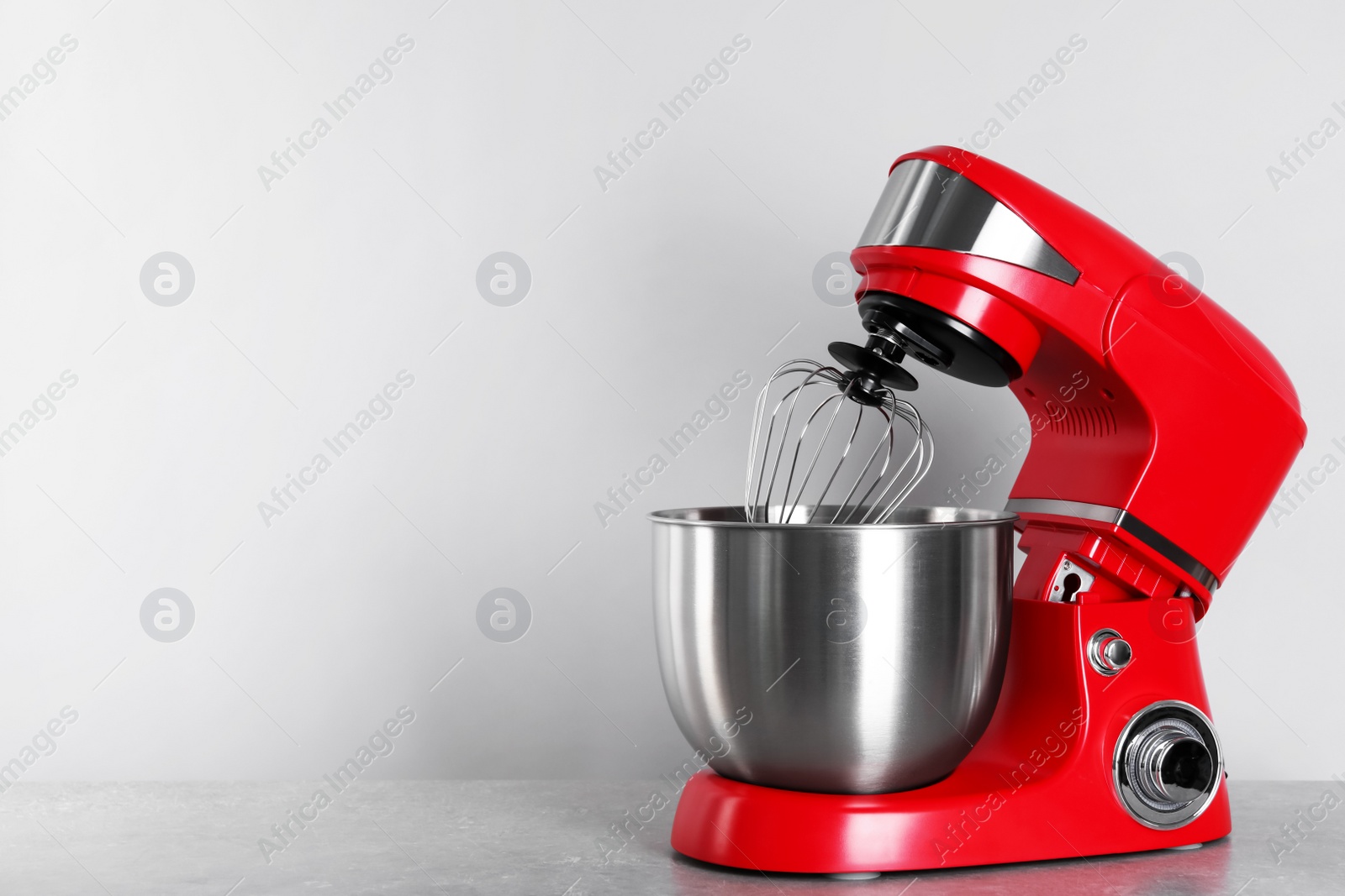 Photo of Modern red stand mixer on light gray table, space for text