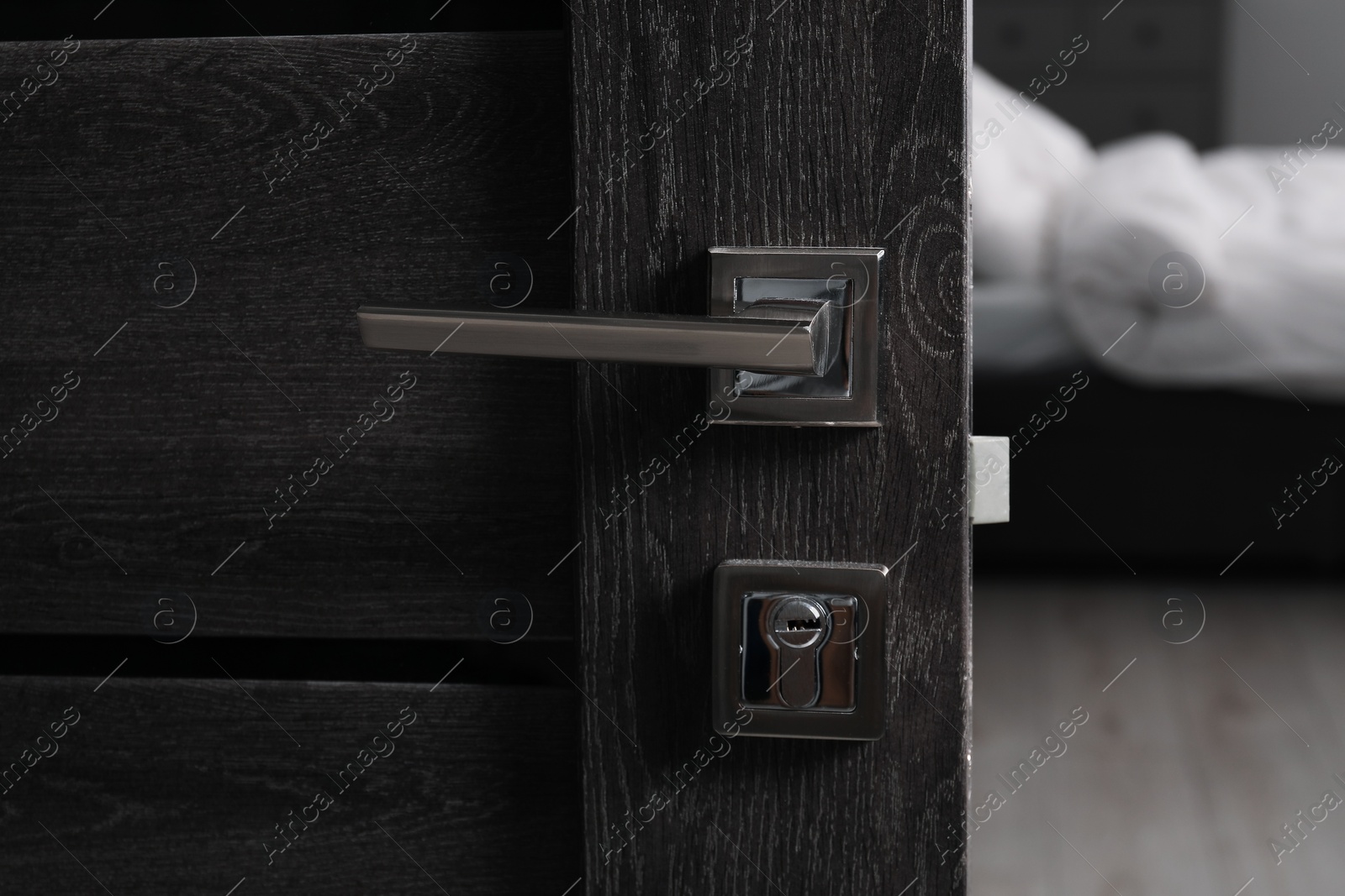 Photo of Open wooden door with metal handle, closeup