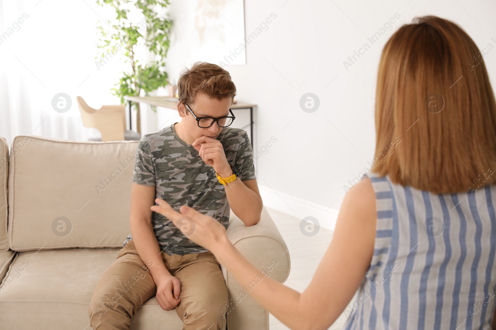 Photo of Mother talking with her teenager son at home