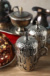 Photo of Tea and Turkish delight served in vintage tea set on wooden table, closeup