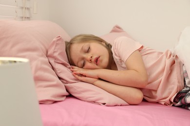 Photo of Little girl snoring while sleeping in bed at home