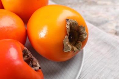 Photo of Delicious ripe persimmons on table, closeup view